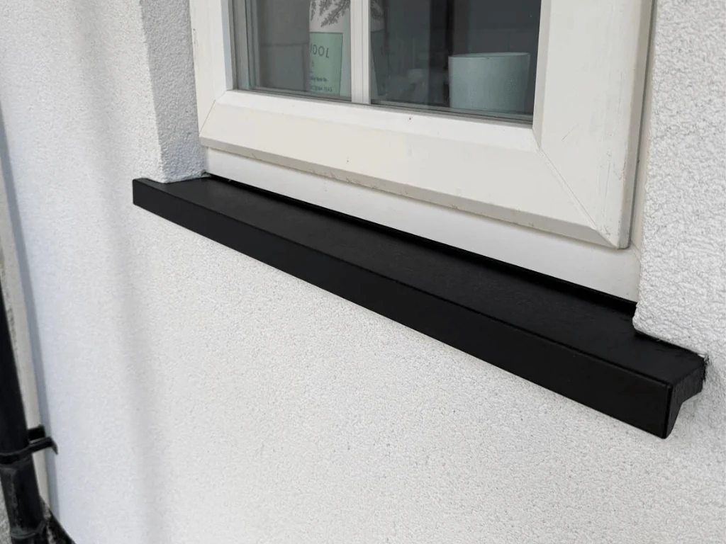 After: black uPVC window sill repaired and refinished in black beneath a white frame
