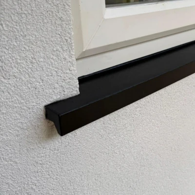 After: black uPVC trim repaired and refinished to match, at the corner of a textured wall